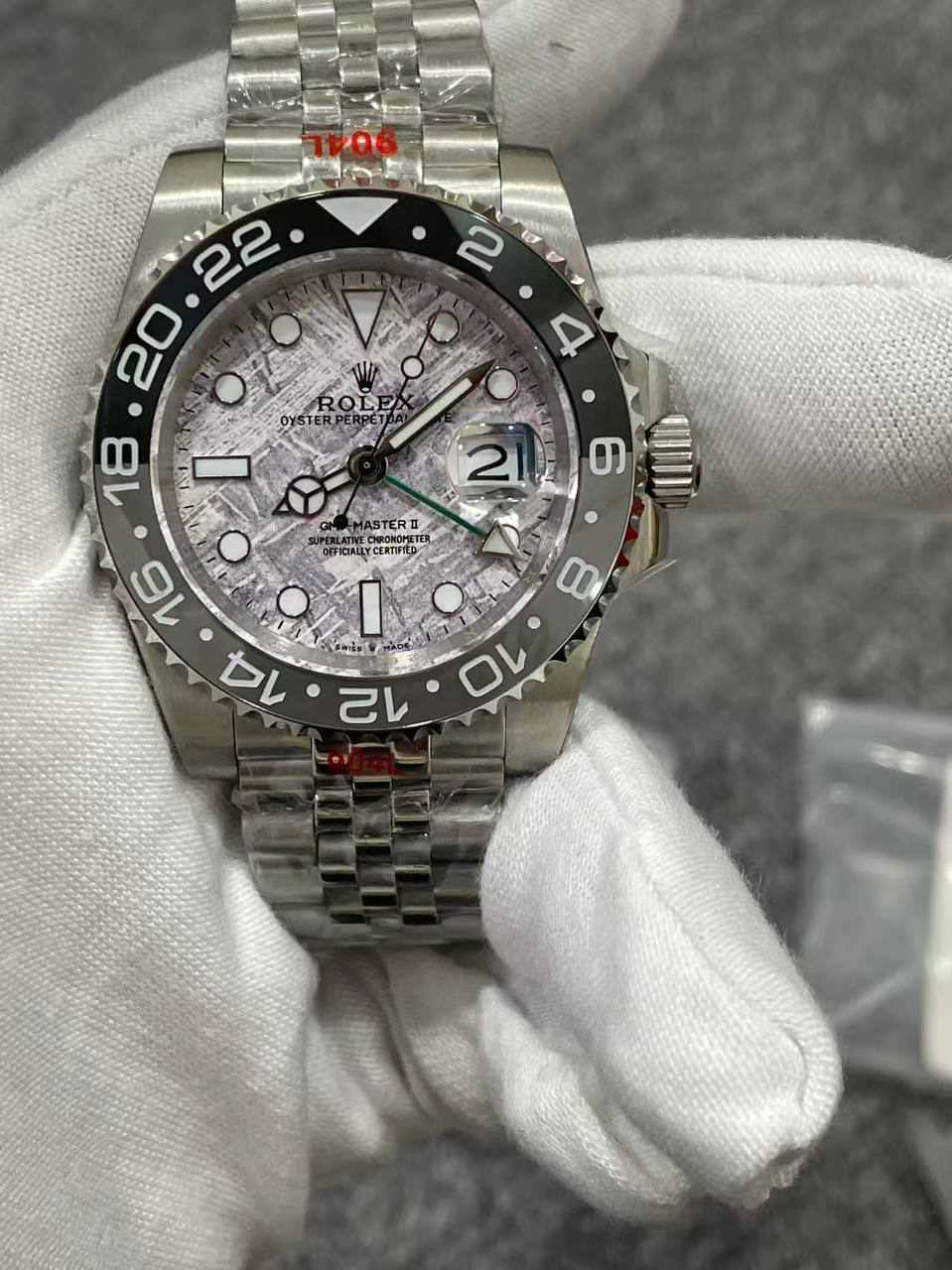 Rolex GMT-Master II, likely reference 126710GRNR, featuring a grey and black ceramic bezel and a meteorite-style dial.  Master Grade